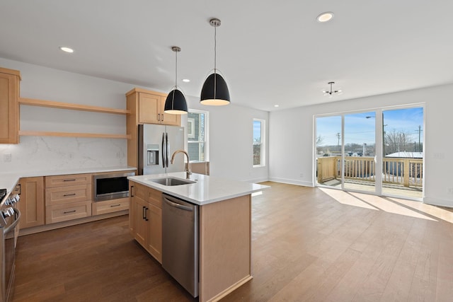 kitchen with appliances with stainless steel finishes, a sink, open shelves, light brown cabinets, and backsplash