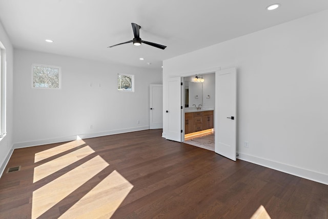 unfurnished bedroom with dark wood finished floors, recessed lighting, baseboards, ensuite bathroom, and a ceiling fan