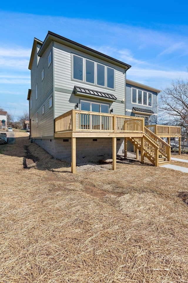 rear view of property with a deck, crawl space, and stairway