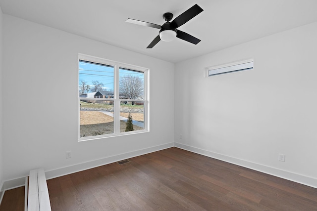 unfurnished room featuring ceiling fan, dark wood-type flooring, and baseboards