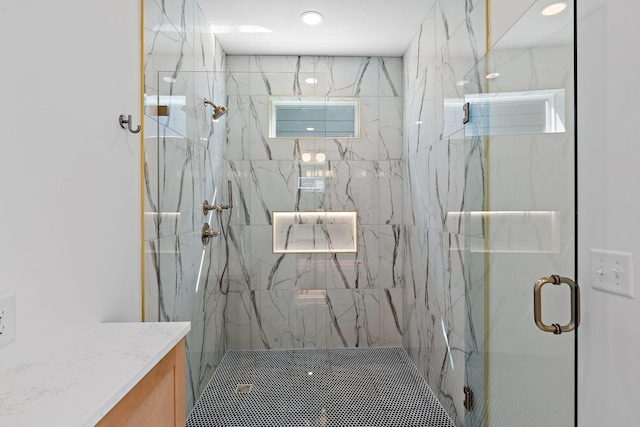 full bath featuring a marble finish shower, vanity, and recessed lighting