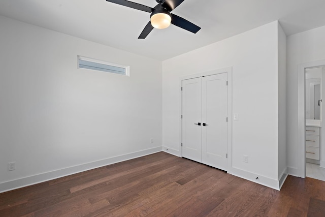 unfurnished bedroom with dark wood-type flooring, baseboards, and a closet