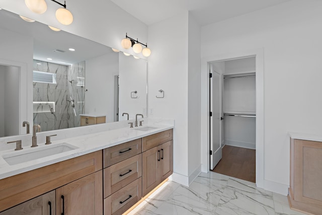 full bath with a marble finish shower, marble finish flooring, baseboards, double vanity, and recessed lighting