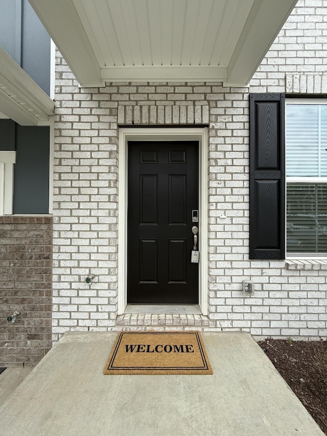 entrance to property featuring brick siding