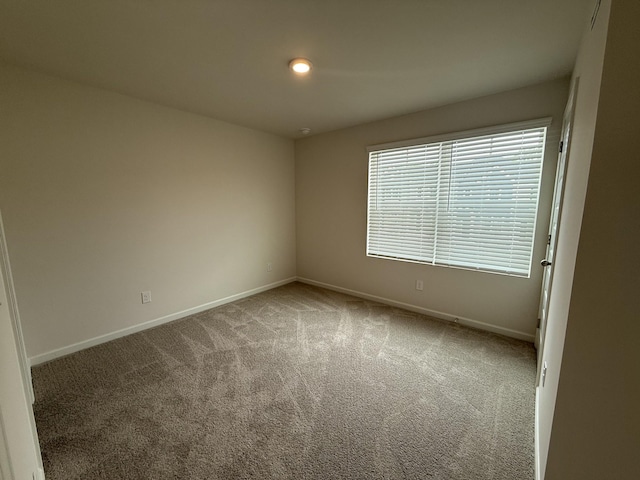 empty room with carpet flooring, baseboards, and recessed lighting