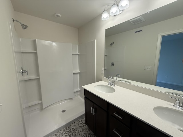 full bathroom featuring a shower stall, double vanity, and tile patterned flooring