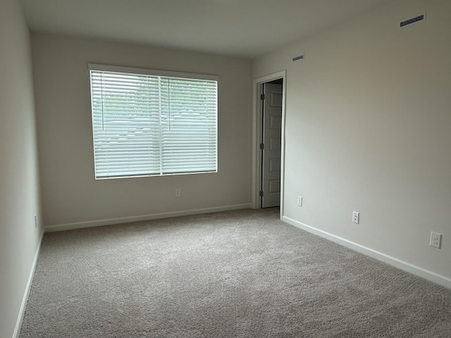 carpeted spare room featuring baseboards