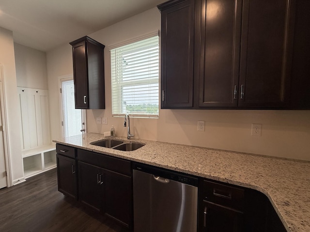 kitchen featuring dishwasher, a sink, dark wood-type flooring, light stone countertops, and dark brown cabinets