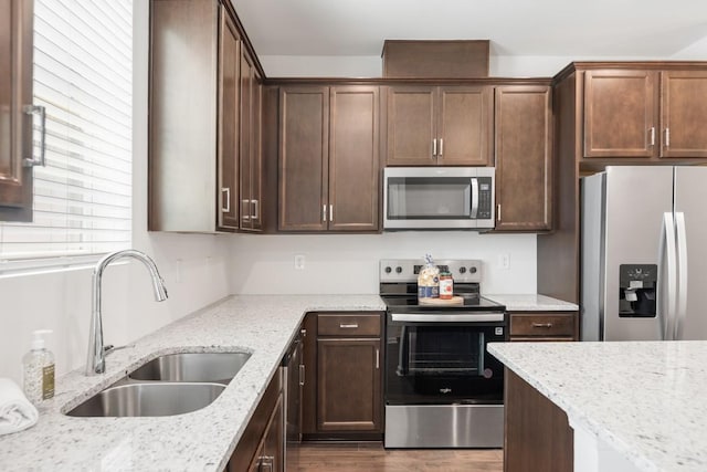 5210 Gladecress Ln, Hermitage, TN 37076 - kitchen with appliances with stainless steel finishes, a sink, wood finished floors, light stone counters, and dark brown cabinetry