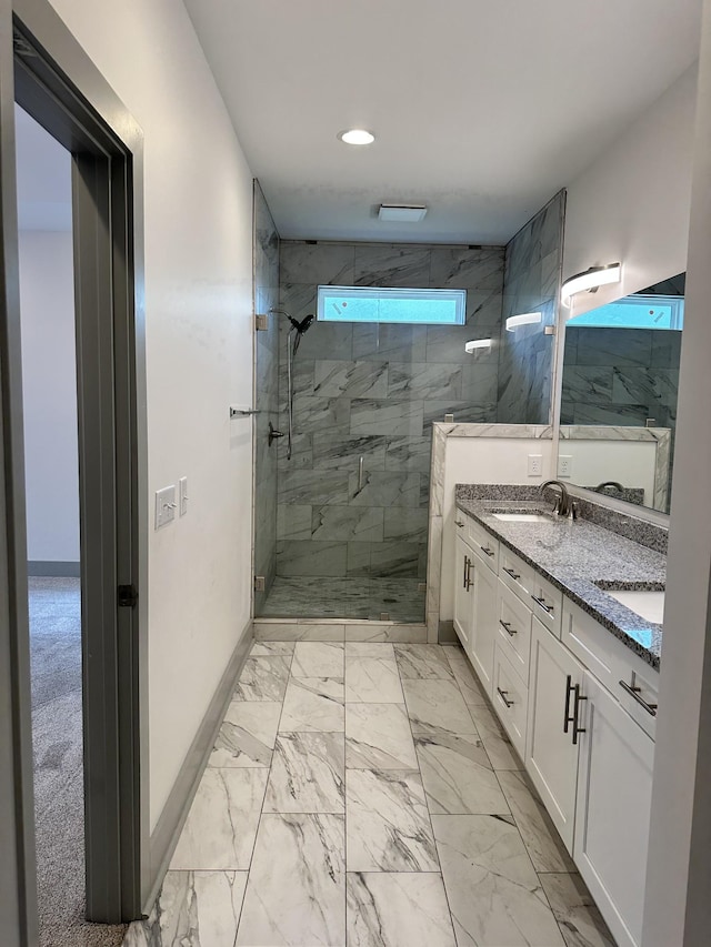 bathroom with marble look tiles, a stall shower, double vanity, baseboards, and recessed lighting