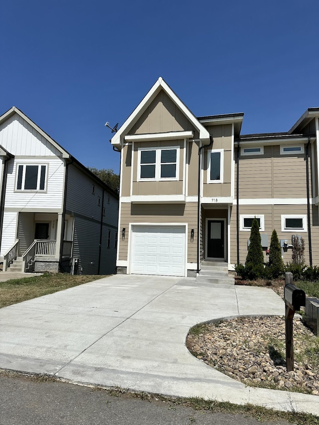 multi unit property featuring board and batten siding, an attached garage, and driveway