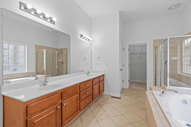 full bathroom featuring a shower stall, healthy amount of natural light, tile patterned floors, and double vanity