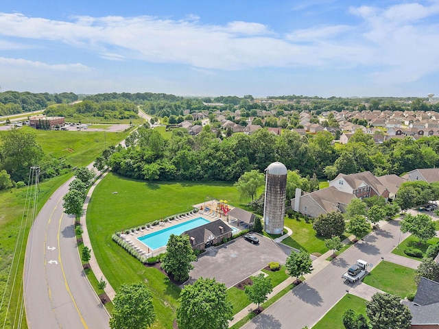 aerial view of a pool area and a tree filled landscape