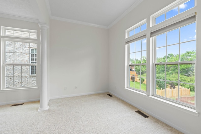 empty room with ornamental molding, carpet floors, decorative columns, and baseboards