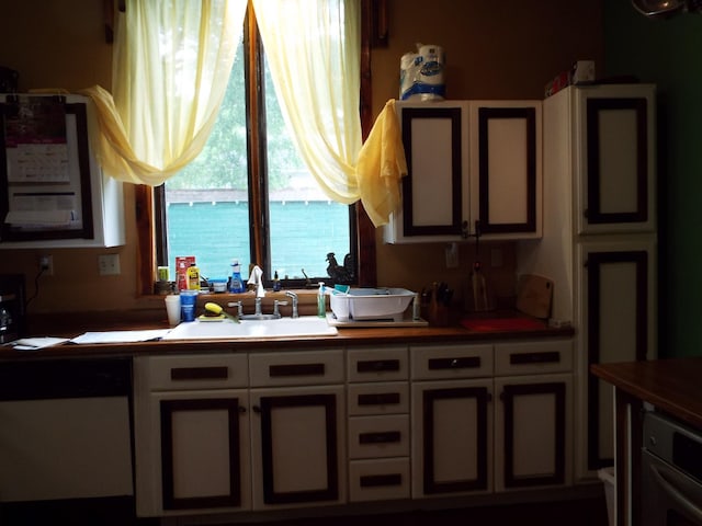 165 E Main St, Alexandria, TN 37012 - kitchen with dishwashing machine, a sink, and white cabinets