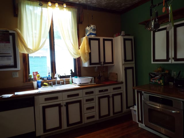 165 E Main St, Alexandria, TN 37012 - kitchen featuring oven, a sink, dishwasher, white cabinetry, and dark wood-style flooring