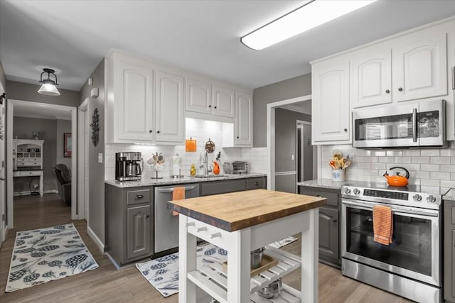 1209 Corlew Dr, Burns, TN 37029 - kitchen featuring stainless steel appliances, gray cabinetry, wooden counters, a sink, and backsplash