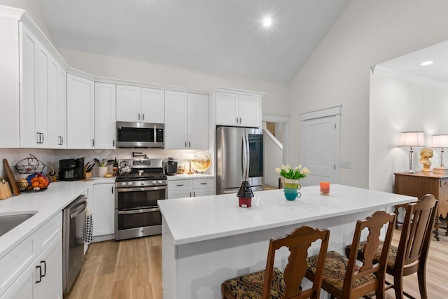 120 Destineys Way, Gruetli Laager, TN 37339 - kitchen with appliances with stainless steel finishes, a breakfast bar, decorative backsplash, vaulted ceiling, and white cabinets