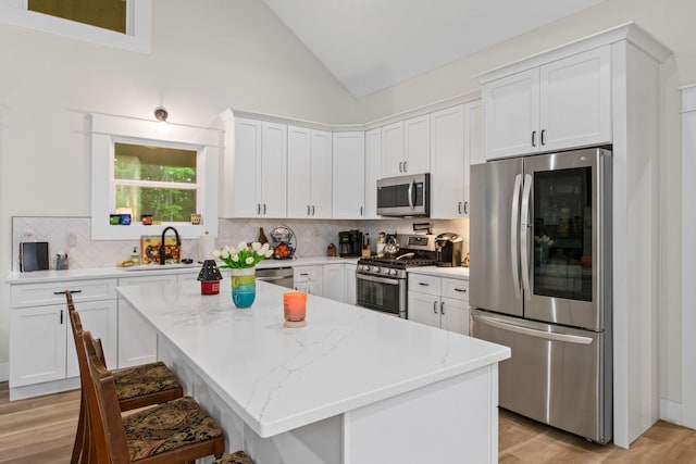 120 Destineys Way, Gruetli Laager, TN 37339 - kitchen with stainless steel appliances, a sink, vaulted ceiling, tasteful backsplash, and white cabinetry