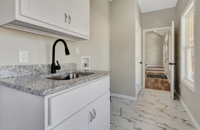 2582 Gap Rd, Altamont, TN 37301 - kitchen with a sink, baseboards, light marble finish floors, white cabinetry, and light stone counters