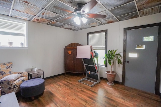 misc room featuring wood finished floors, a ceiling fan, and baseboards