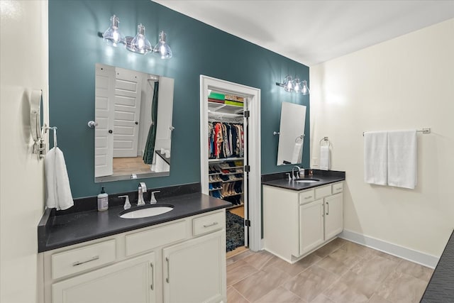 429 Finnhorse Ln, Franklin, TN 37064 - full bathroom featuring two vanities, a spacious closet, and baseboards
