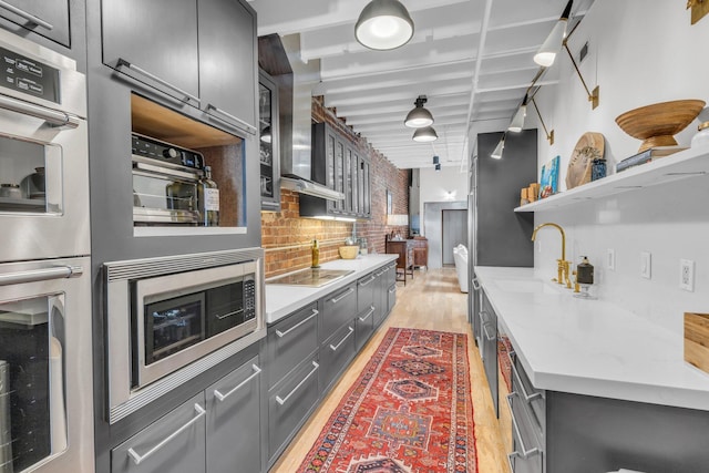 55 E Main St # 208, Chattanooga, TN 37408 - kitchen with a sink, appliances with stainless steel finishes, light wood-style floors, backsplash, and open shelves