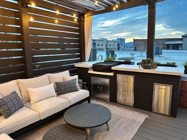 55 E Main St # 208, Chattanooga, TN 37408 - deck at dusk with a pergola, exterior kitchen, and outdoor lounge area