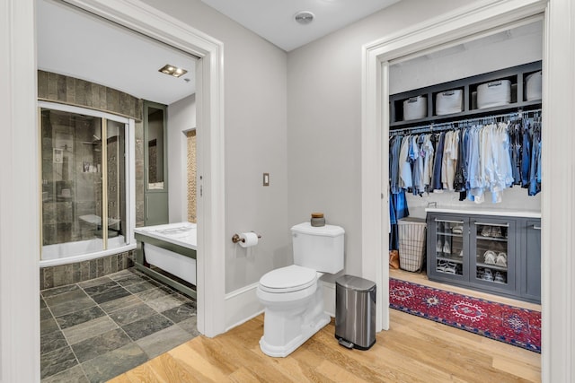 55 E Main St # 208, Chattanooga, TN 37408 - bathroom featuring toilet, tiled shower / bath combo, baseboards, vanity, and a walk in closet