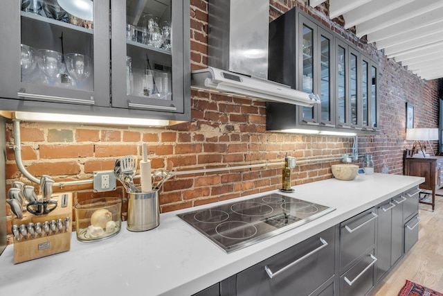55 E Main St # 208, Chattanooga, TN 37408 - kitchen featuring black electric stovetop, exhaust hood, glass insert cabinets, light countertops, and gray cabinetry