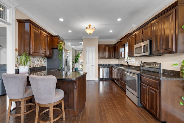 1607 Edgewater Ln, Clarksville, TN 37043 - kitchen with appliances with stainless steel finishes, a peninsula, dark wood-type flooring, a sink, and recessed lighting
