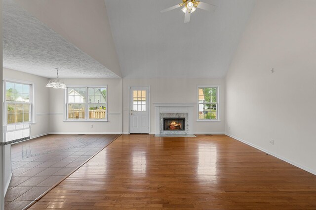 1332 Dodd Trl, Murfreesboro, TN 37128 - unfurnished living room featuring a chandelier, wood finished floors, a premium fireplace, baseboards, and ceiling fan