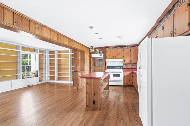 411 Tremont Dr, Murfreesboro, TN 37130 - kitchen featuring white appliances, light wood-type flooring, decorative light fixtures, wooden walls, and a center island