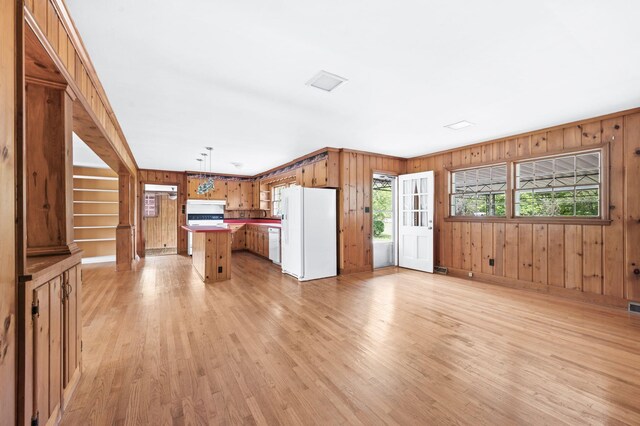 411 Tremont Dr, Murfreesboro, TN 37130 - kitchen featuring white appliances, light wood-style floors, wooden walls, open floor plan, and a center island