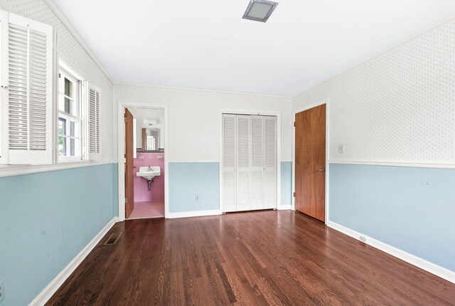 411 Tremont Dr, Murfreesboro, TN 37130 - unfurnished bedroom with wood finished floors, a closet, wallpapered walls, crown molding, and baseboards