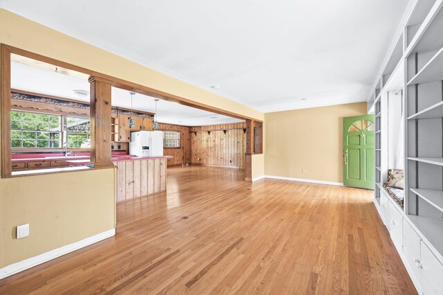 411 Tremont Dr, Murfreesboro, TN 37130 - unfurnished living room featuring light wood-style floors, baseboards, a sink, and wooden walls