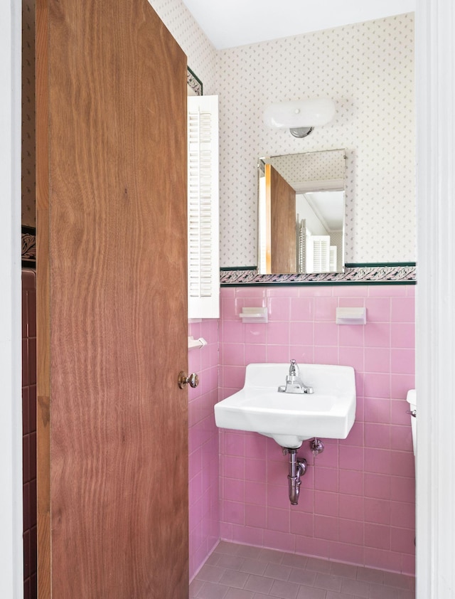 411 Tremont Dr, Murfreesboro, TN 37130 - bathroom featuring wallpapered walls, tile walls, a wainscoted wall, and a sink