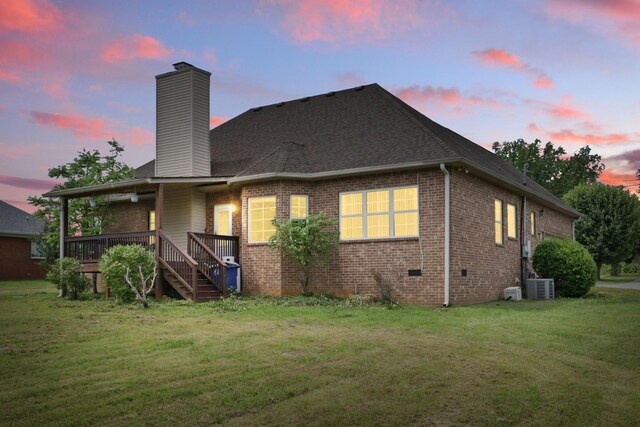 208 Sunnyside Dr, Chapel Hill, TN 37034 - back of house at dusk with a chimney, a yard, brick siding, and central air condition unit