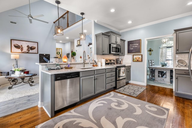 kitchen with stainless steel appliances, a sink, gray cabinetry, crown molding, and recessed lighting