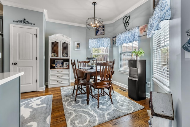 dining area featuring crown molding, a chandelier, wood finished floors, and baseboards