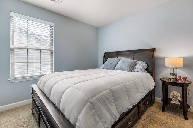 bedroom with light colored carpet and baseboards