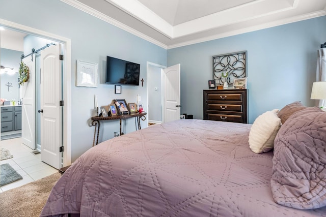 tiled bedroom featuring crown molding, a barn door, a raised ceiling, and ensuite bathroom