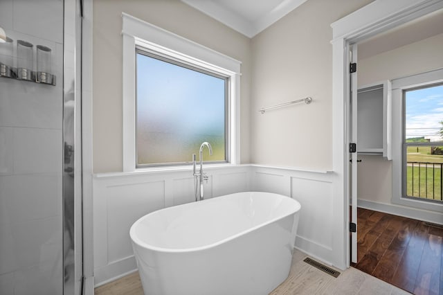 11731 Milton St, Milton, TN 37118 - bathroom featuring wood finished floors, a wainscoted wall, a freestanding tub, and a decorative wall