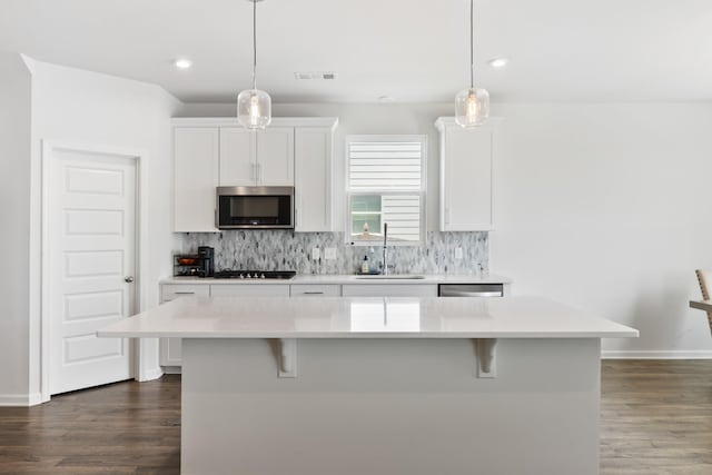 1080 Laurel Valley Ln, Mount Juliet, TN 37122 - kitchen featuring appliances with stainless steel finishes, dark wood-style floors, a sink, a breakfast bar, and light countertops