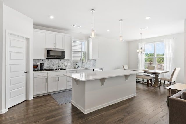 1080 Laurel Valley Ln, Mount Juliet, TN 37122 - kitchen with stainless steel microwave, a sink, dark wood-style floors, a kitchen island, and light countertops