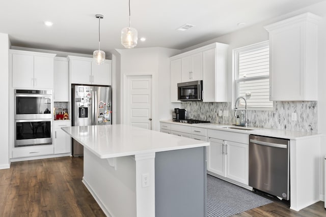 1080 Laurel Valley Ln, Mount Juliet, TN 37122 - kitchen with stainless steel appliances, a sink, decorative backsplash, a kitchen island, and dark wood finished floors