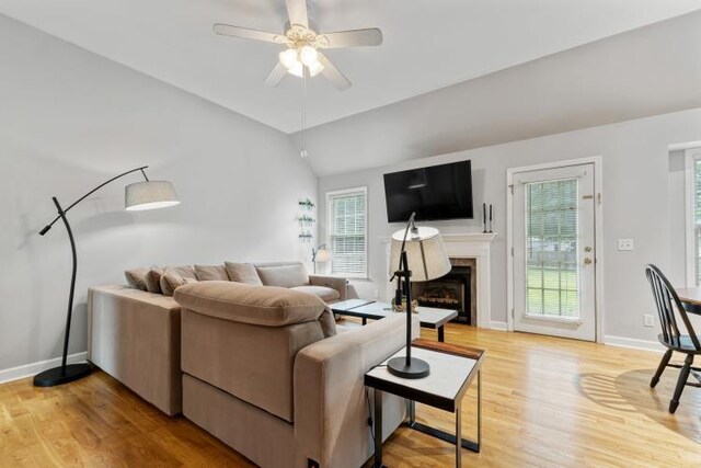 210 Highland Trl, Estill Springs, TN 37330 - living room featuring light wood-style flooring, a ceiling fan, vaulted ceiling, a fireplace, and baseboards