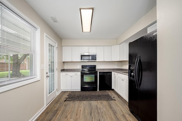 205 Blue Lake Dr, Tullahoma, TN 37388 - kitchen with black appliances, dark wood-style floors, dark countertops, and white cabinetry