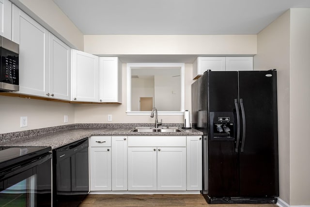 205 Blue Lake Dr, Tullahoma, TN 37388 - kitchen with black appliances, a sink, wood finished floors, and white cabinetry