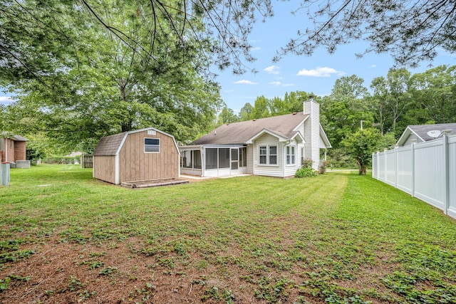 205 Blue Lake Dr, Tullahoma, TN 37388 - rear view of house with a sunroom, a chimney, a shed, and an outdoor structure